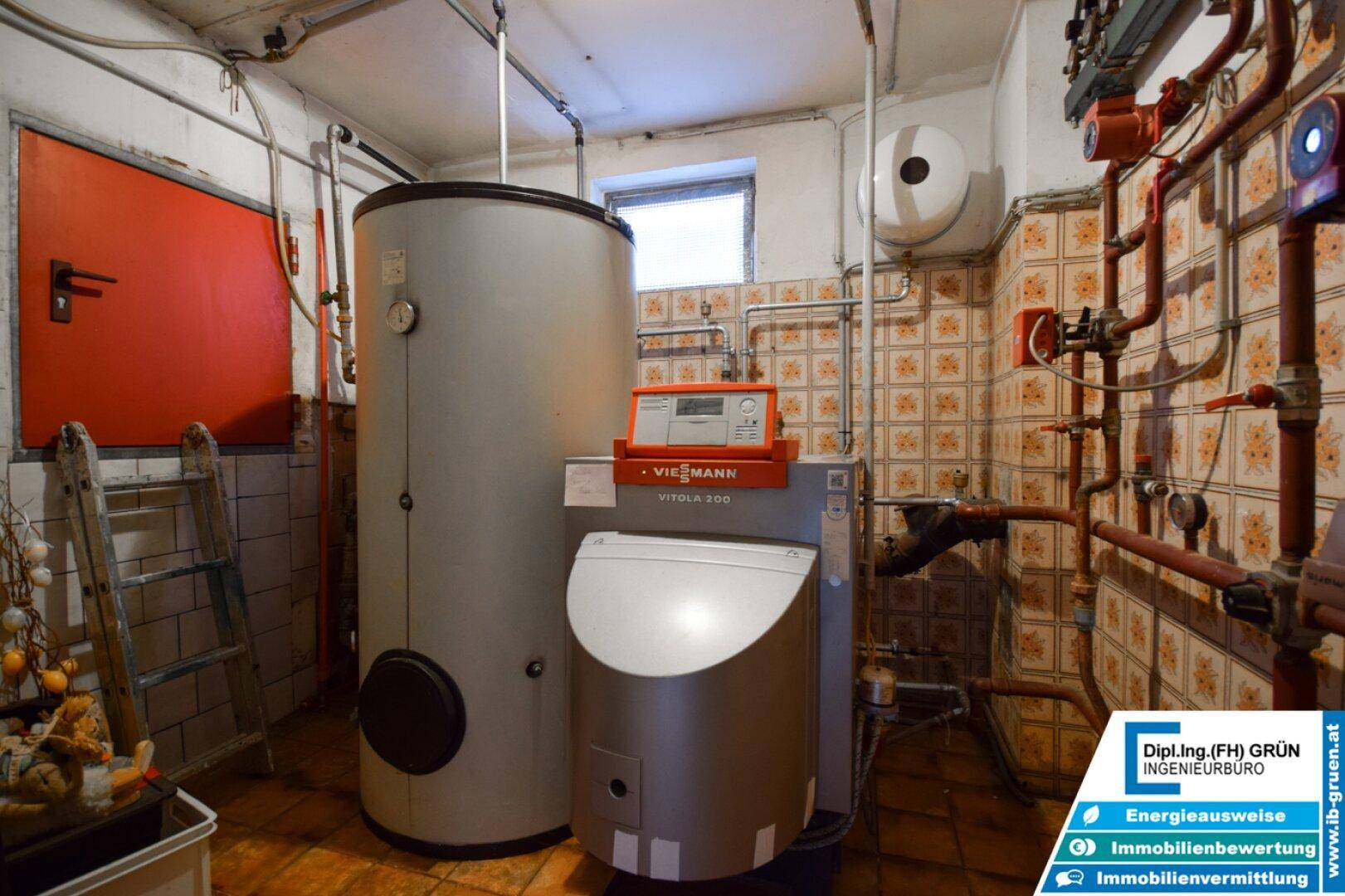 Heizungsraum mit Viessmann-Anlage, Warmwasserspeicher und gefliesten Wänden im Kellerbereich.