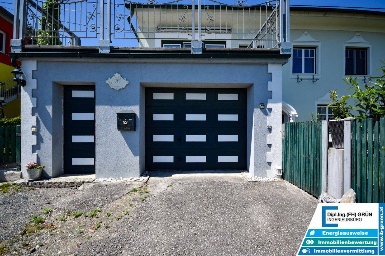 Nahaufnahme der Garage mit modernem Tor und separatem Eingang zum Haus.