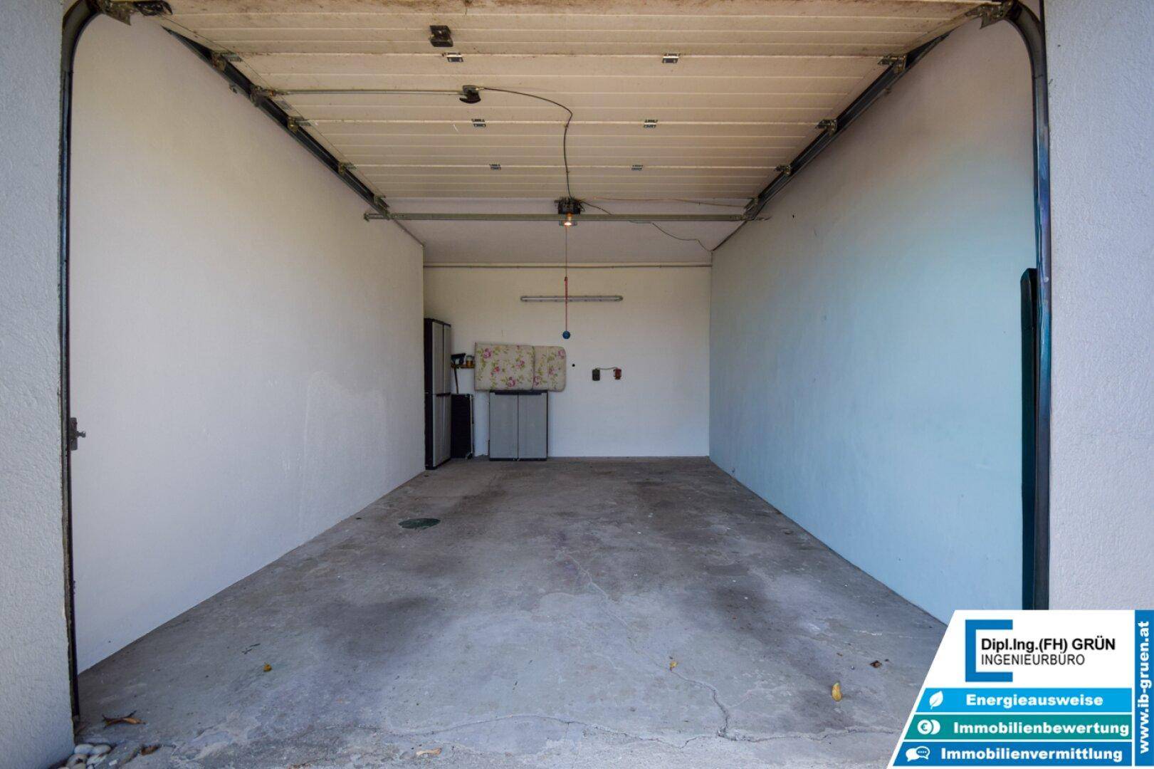 Geräumige Garage mit Betonboden und ausreichend Platz für ein Fahrzeug und Lagerung.