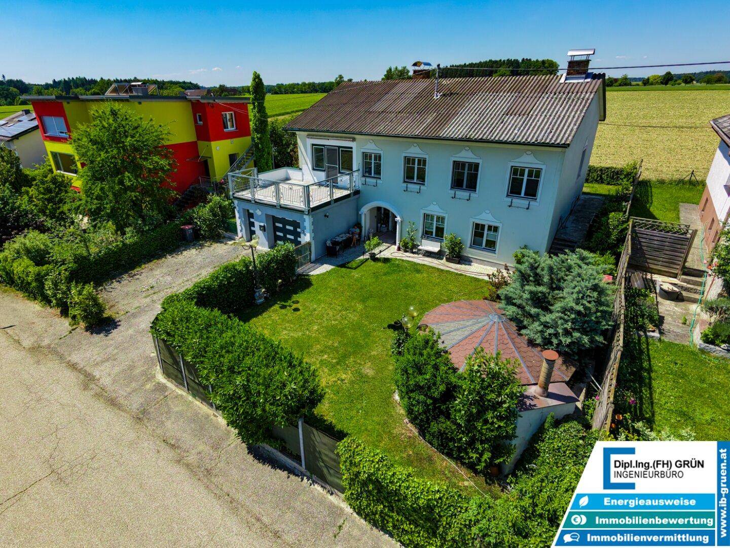 Luftaufnahme des Anwesens mit großem Garten, Garage und umliegender Landschaft.