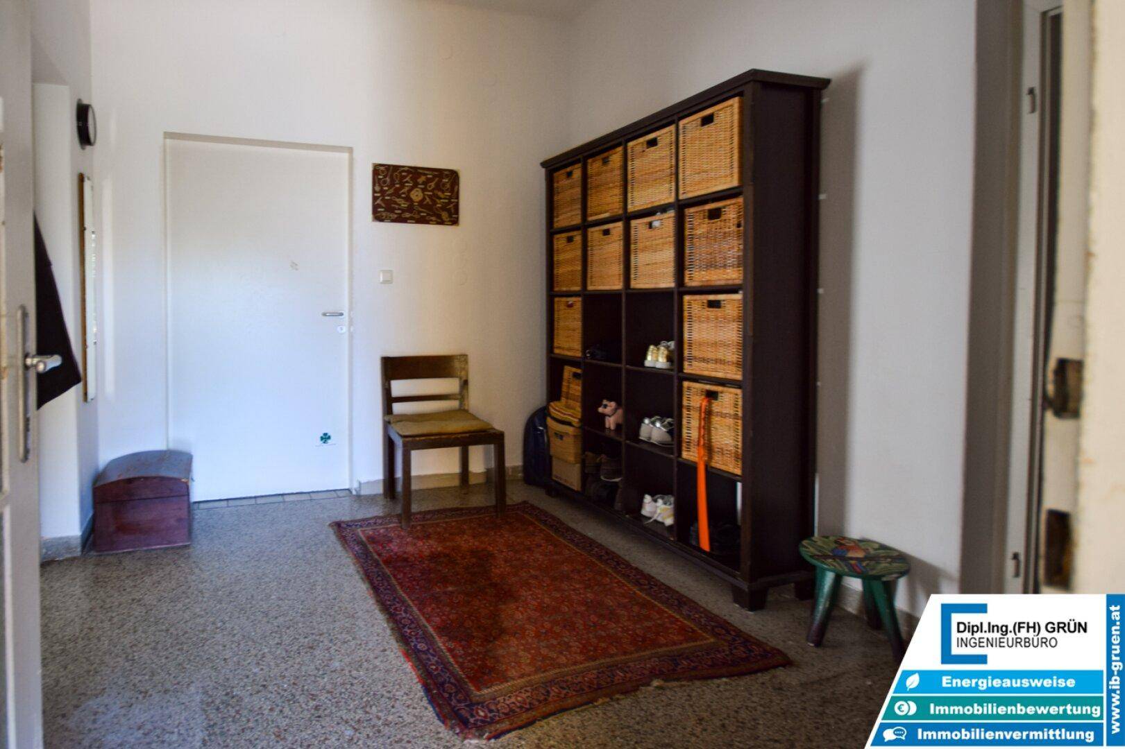 Geräumiger Flur mit Teppich, Schuhregal und Garderobe im Eingangsbereich.
