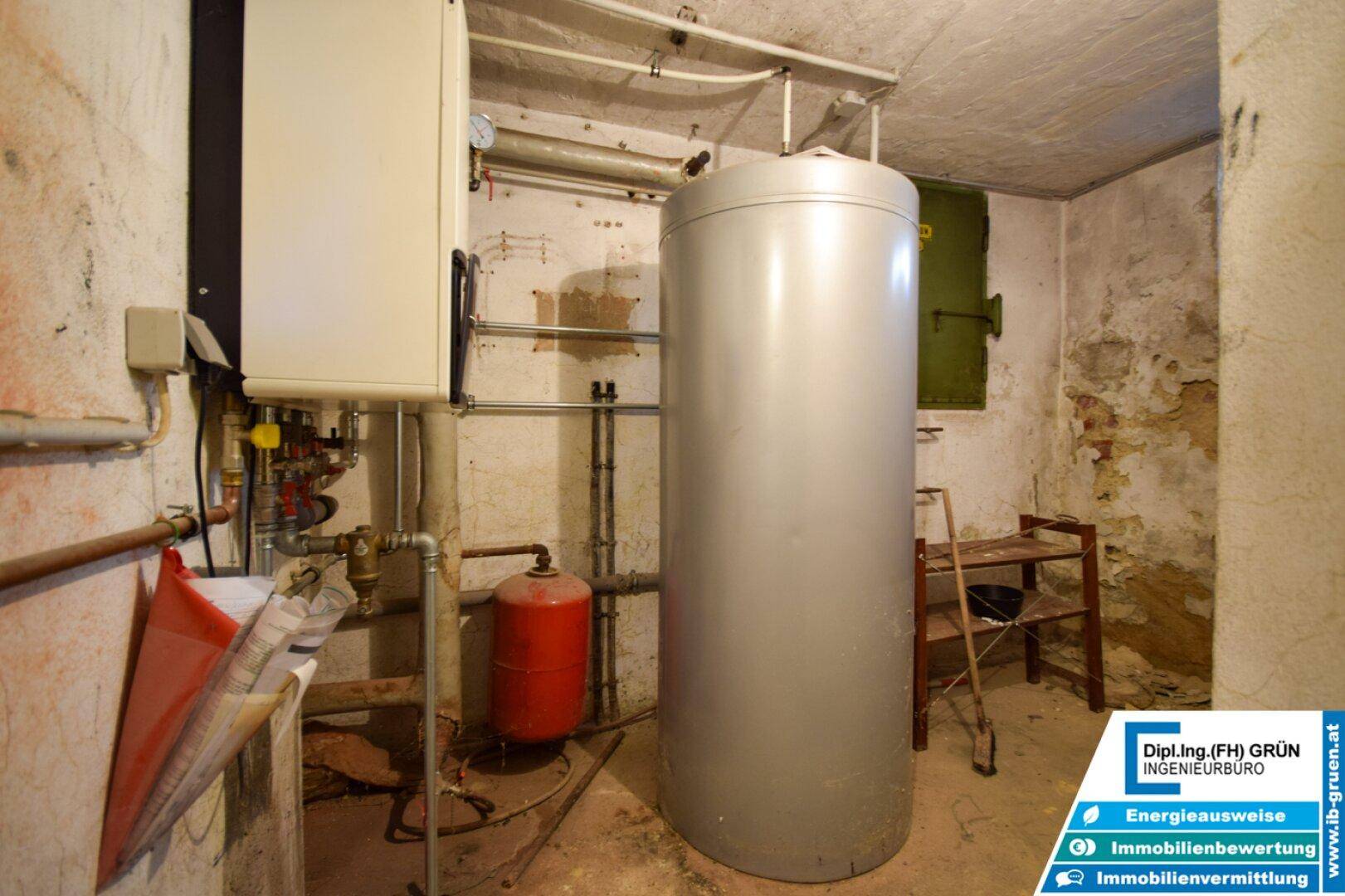 Heizungsraum im Keller mit großem Warmwasserspeicher und Heizungsanlage.