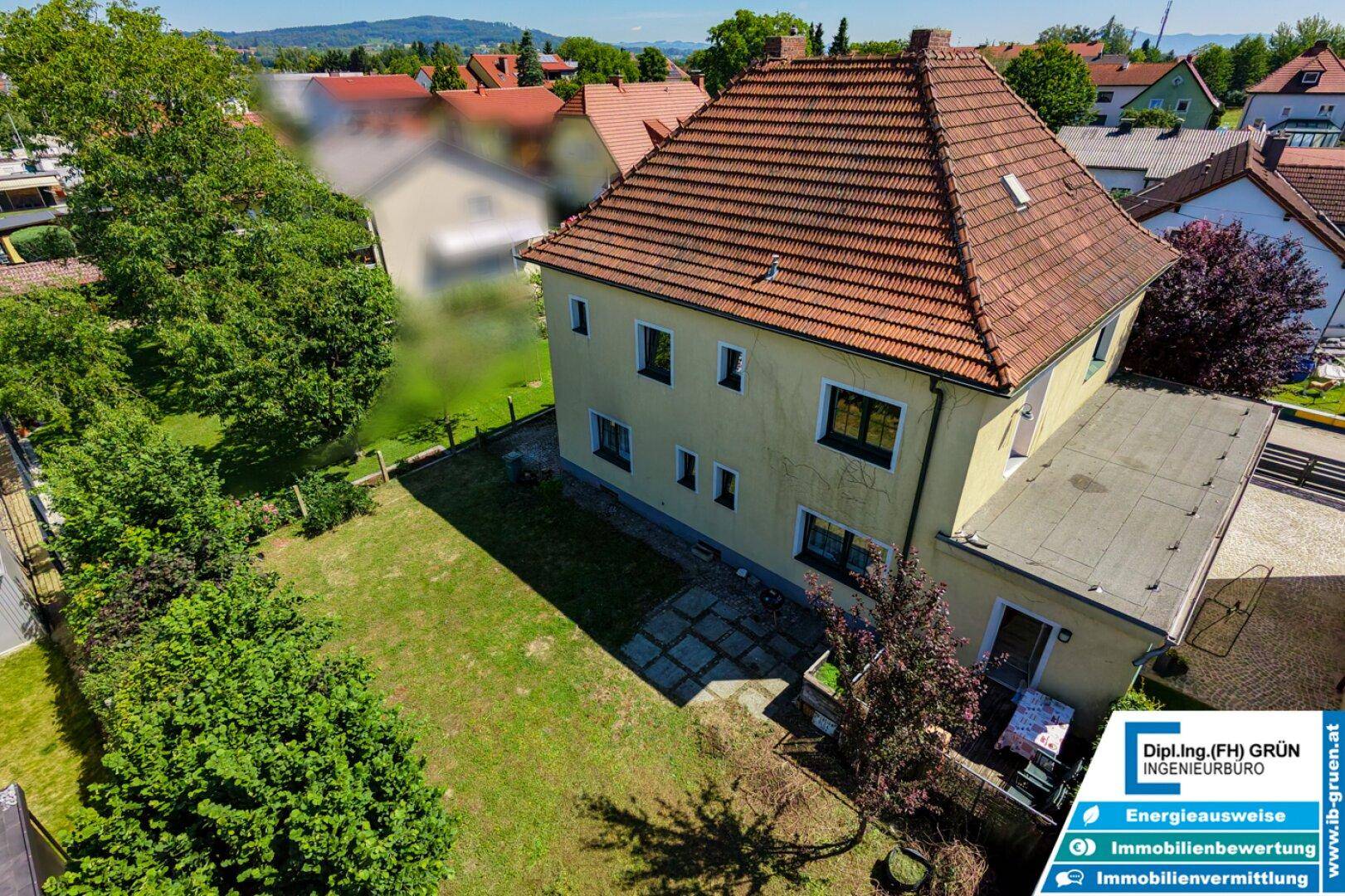 Luftaufnahme des Hauses mit großem Gartenbereich, Rasenfläche und Terrasse.