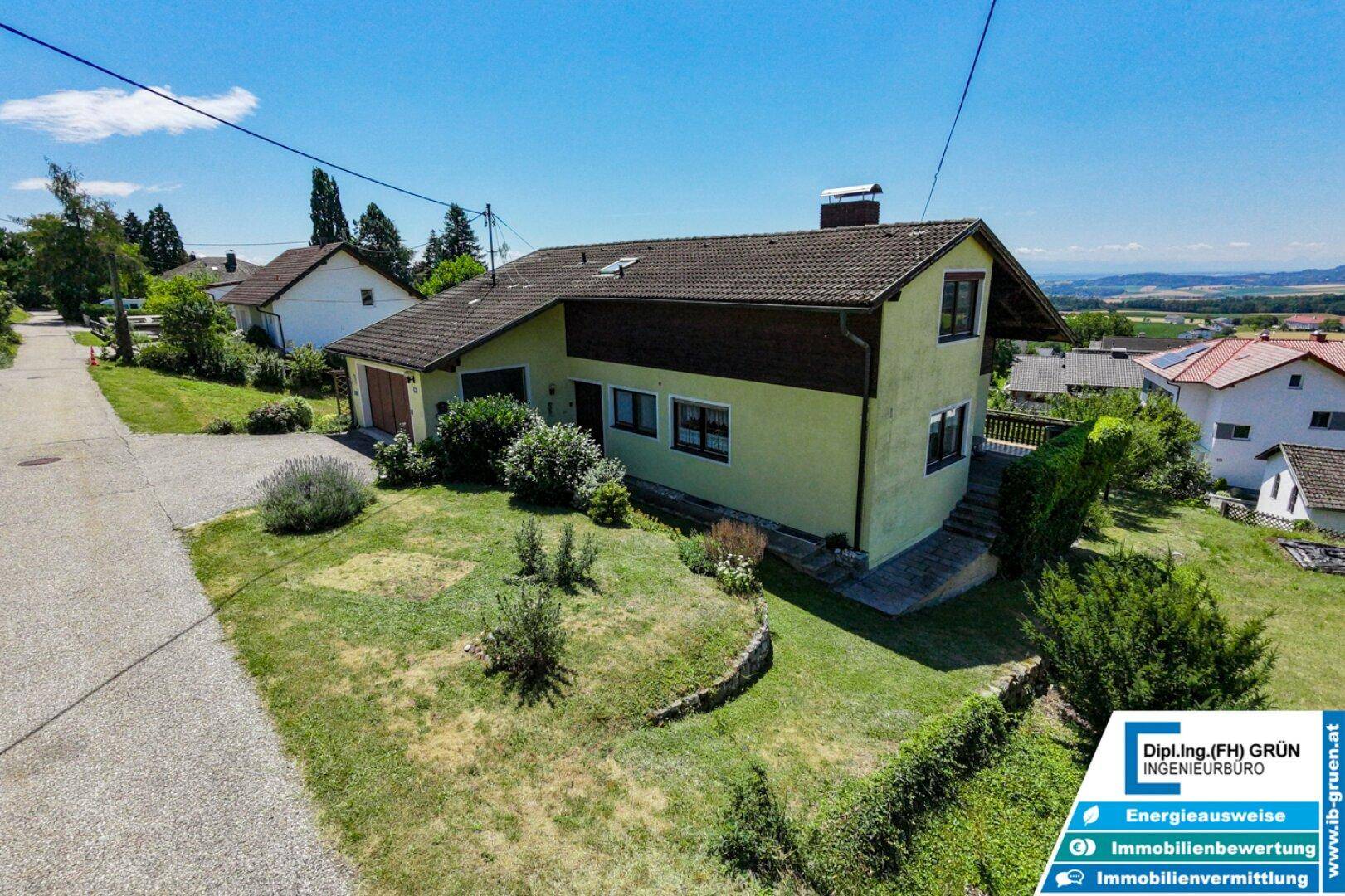 Ansicht des Hauses von der Seite mit Zufahrt und umliegender Landschaft.