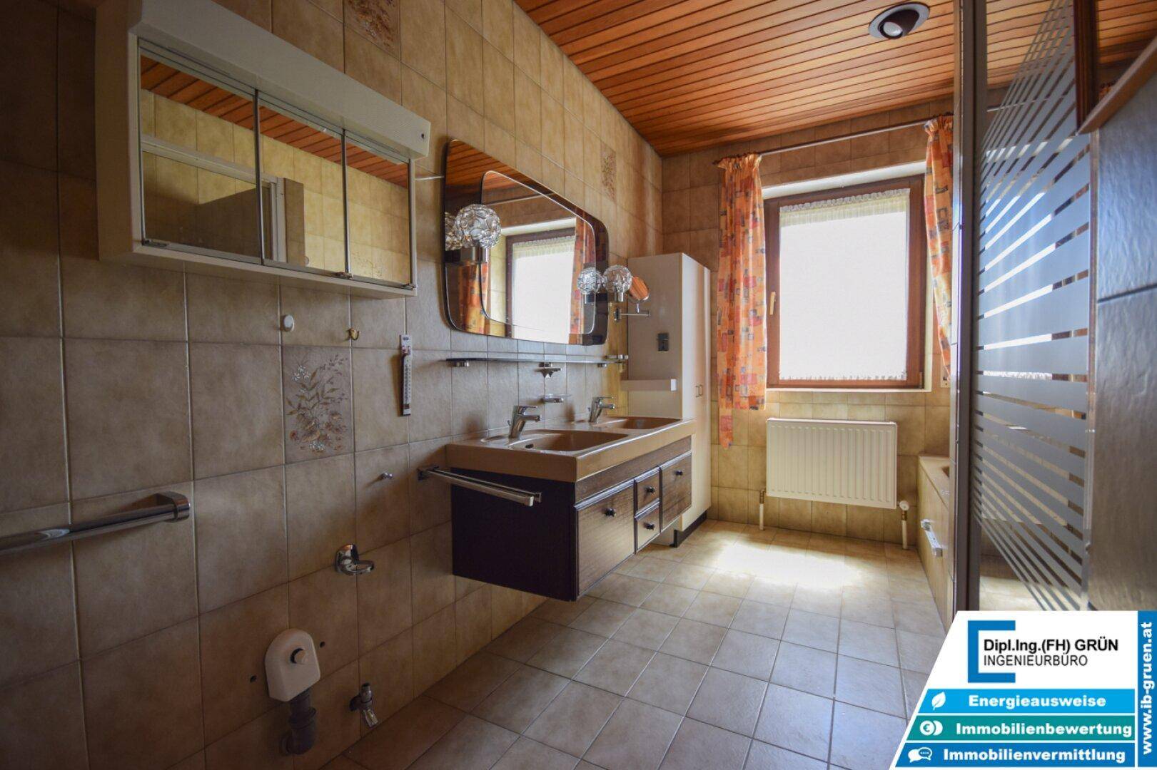 Geräumiges Badezimmer mit Doppelwaschbecken, Dusche und Fenster, ausgestattet mit Holzdecke.