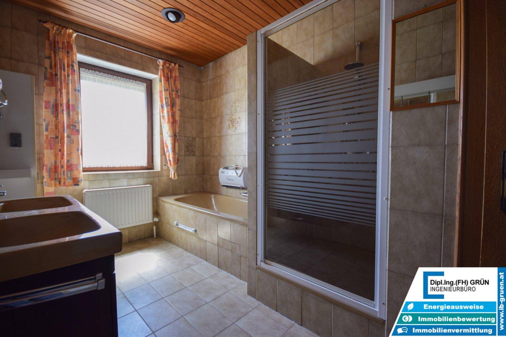 Badezimmer mit Fenster, Badewanne und Duschkabine, bietet natürliche Belüftung.