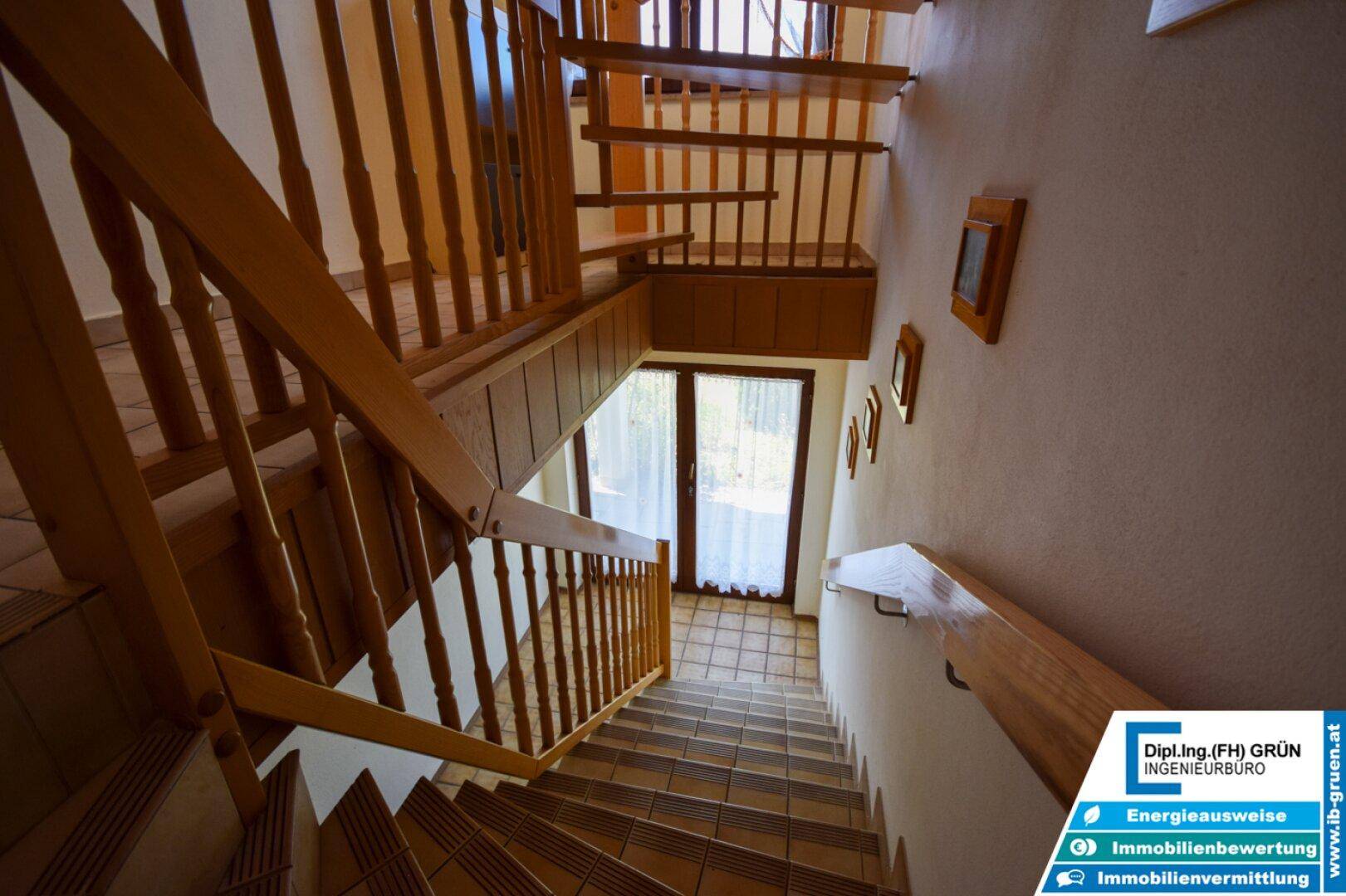 Holztreppe mit Geländer, die verschiedene Ebenen des Hauses miteinander verbindet.