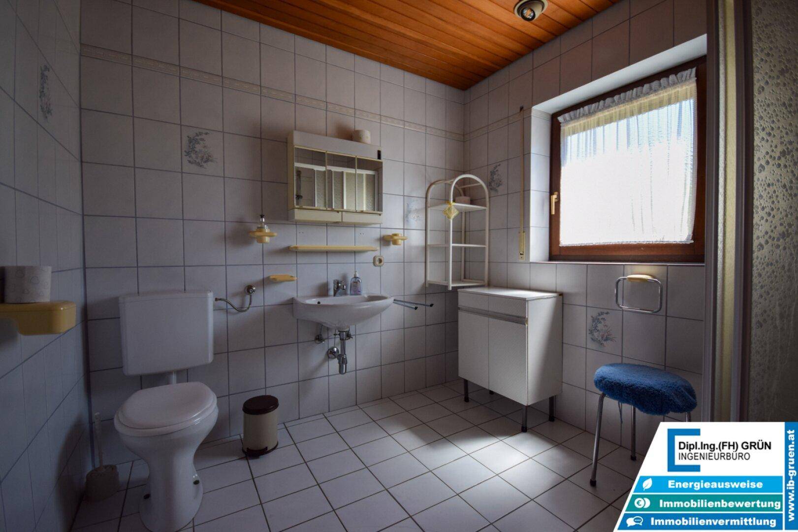 Badezimmer im 80er-Jahre-Stil mit Fliesen, Waschbecken und WC.