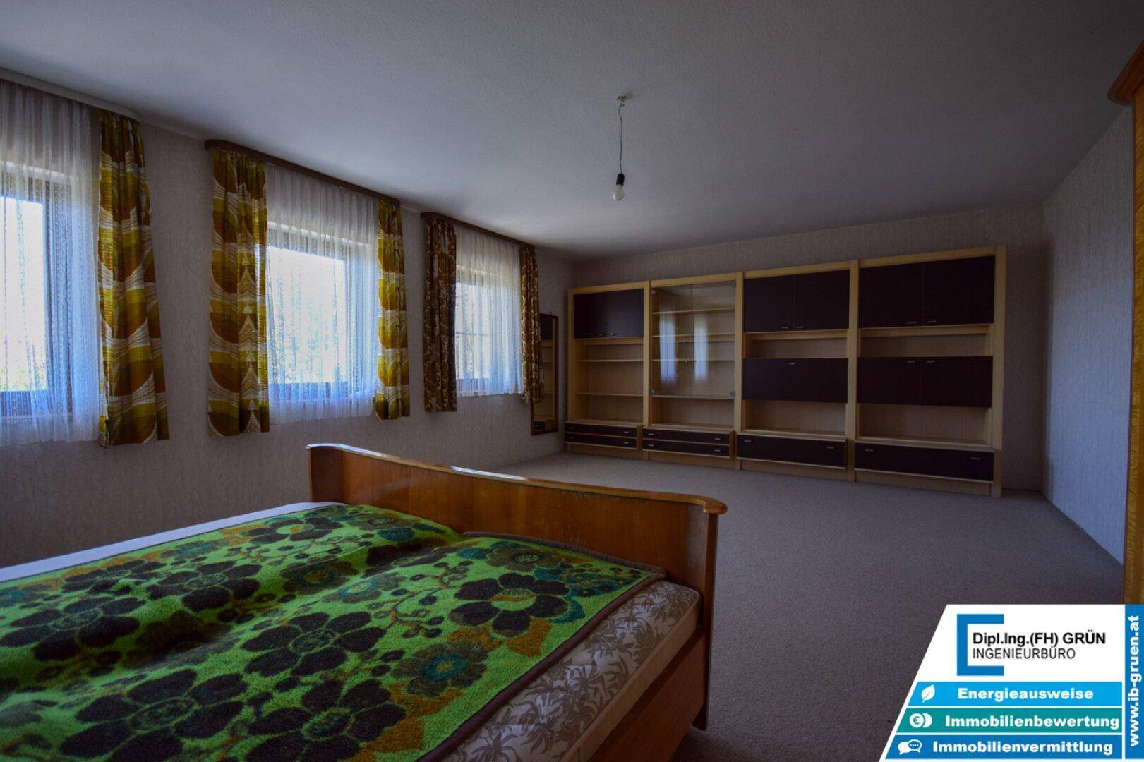 Schlafzimmer mit Teppichboden, Einbauschränken und Blick nach draußen.