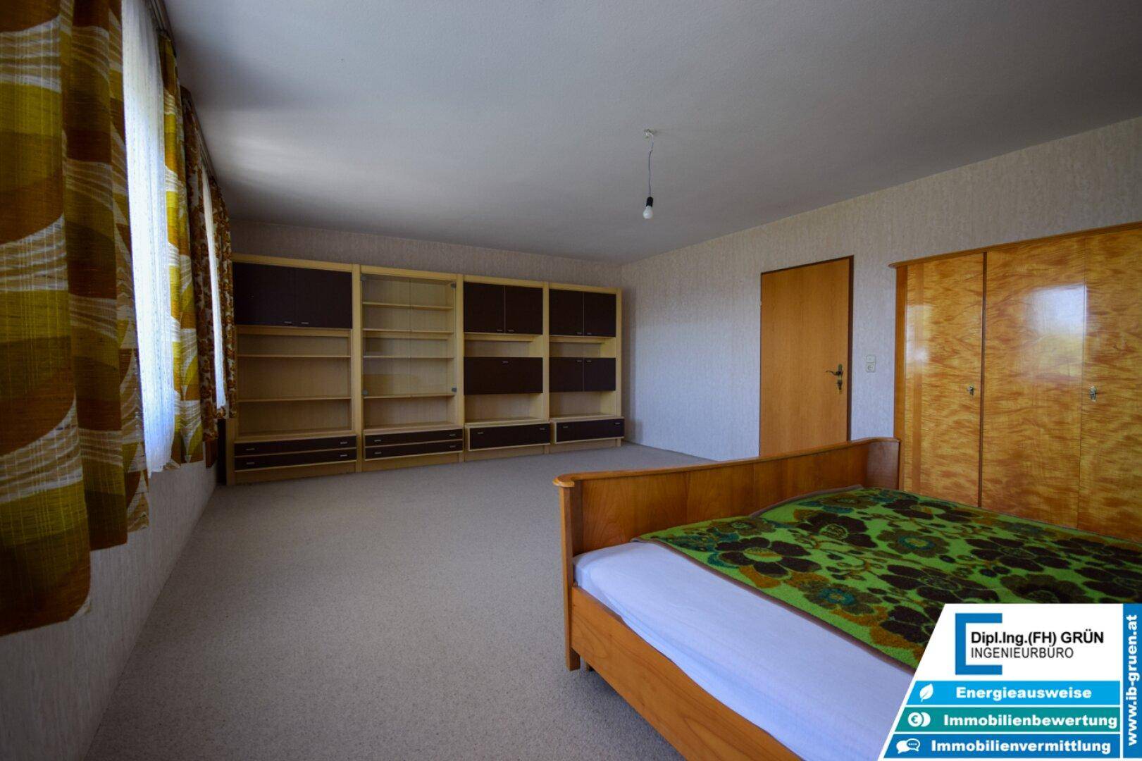 Helles Schlafzimmer mit Teppichboden, Holzmöbeln und Einbauschränken.