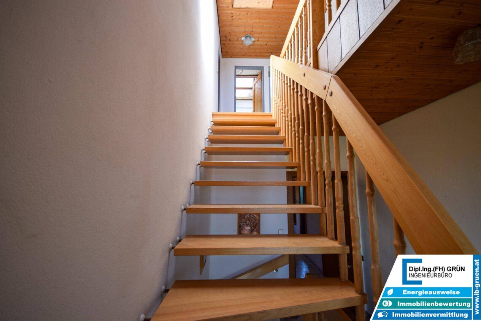 Holztreppe führt nach oben, mit Holzverkleidung an der Decke.