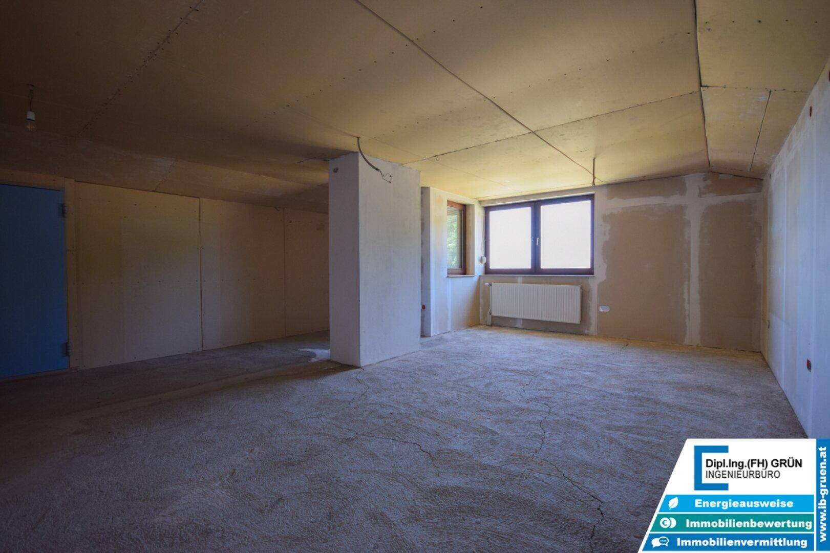 Heller Rohbau-Raum mit Fenster und Heizkörper, ideal für individuelle Gestaltung und Nutzung.
