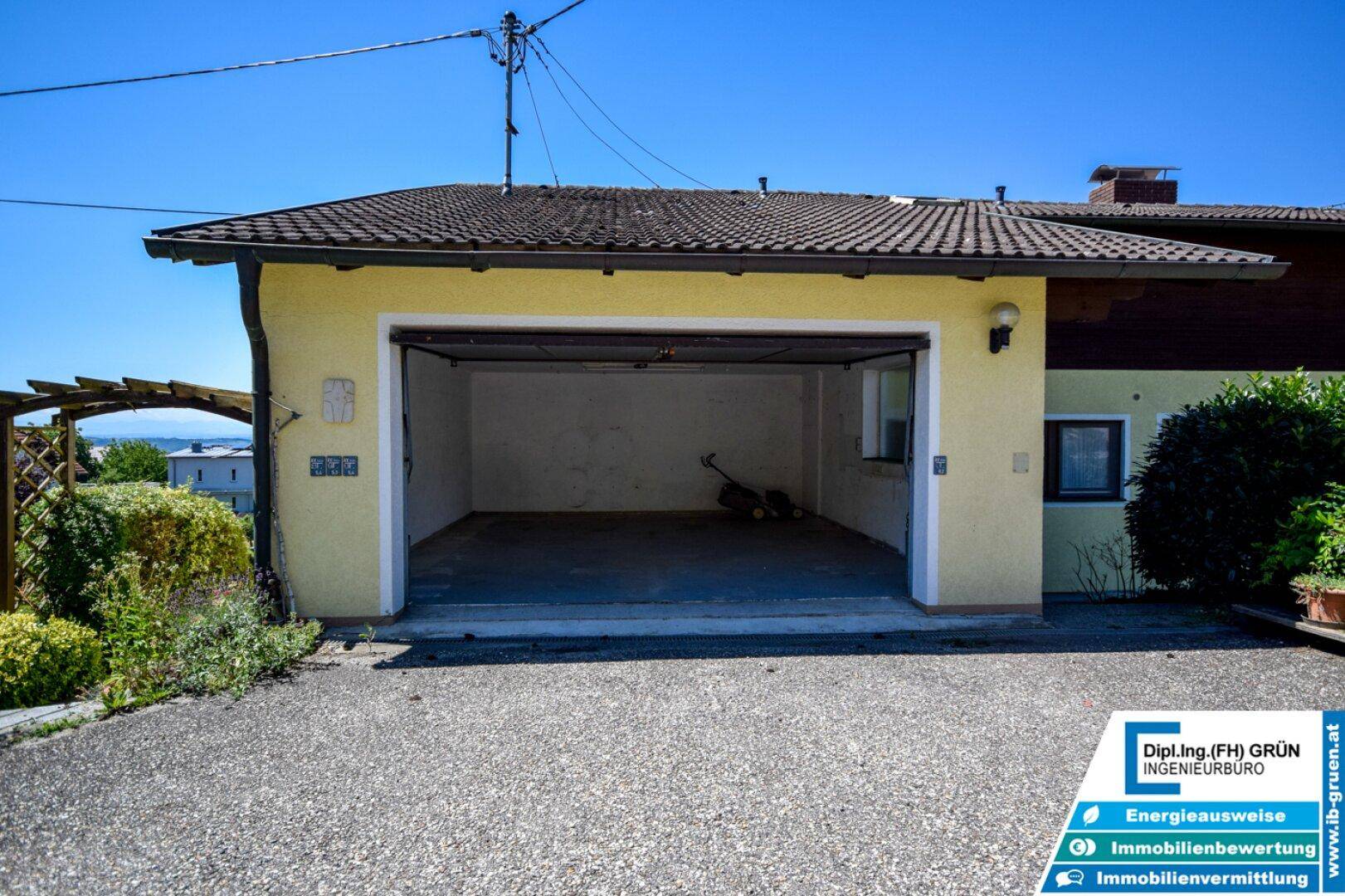 Freistehende Doppelgarage mit offenem Tor und gepflasterter Zufahrt, gut zugänglich.
