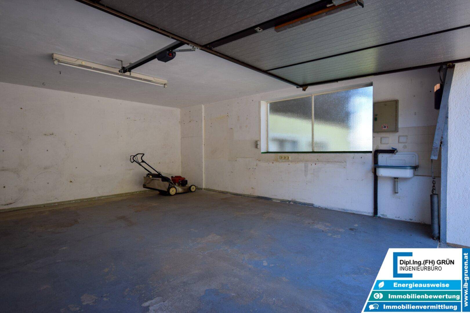 Garage mit Fenster, Waschbecken und Rasenmäher, ideal für Hobby und Lagerung von Geräten.