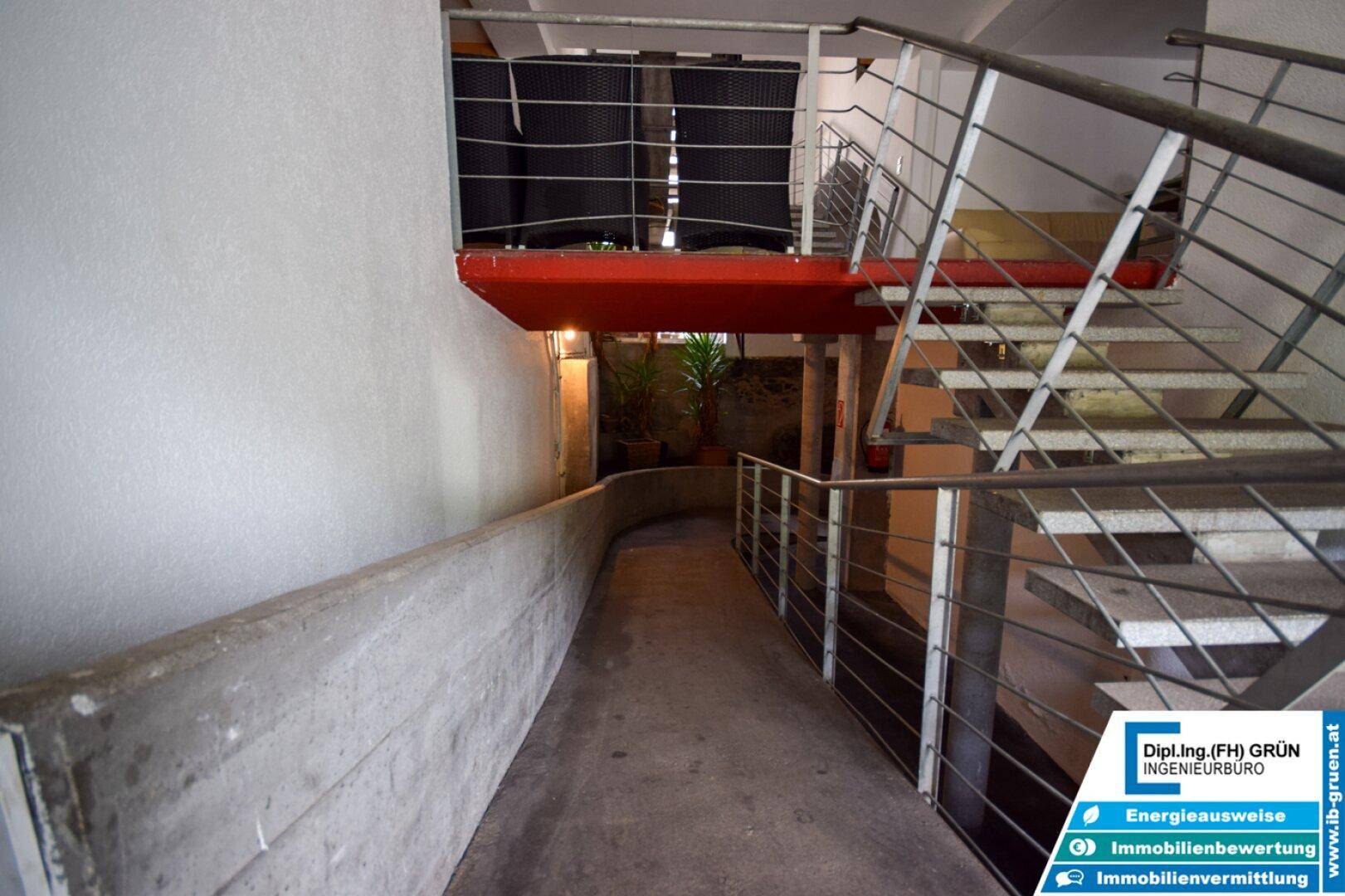 Außenrampe für barrierefreien Zugang zum Gebäude mit Treppen im Hintergrund.