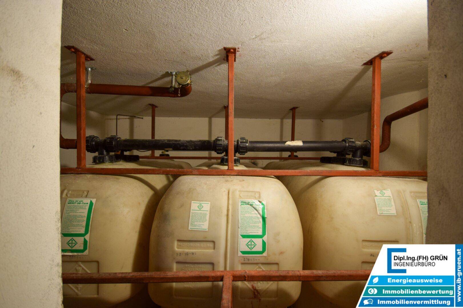 Technikraum mit großen Wassertanks und sichtbaren Rohrleitungen.