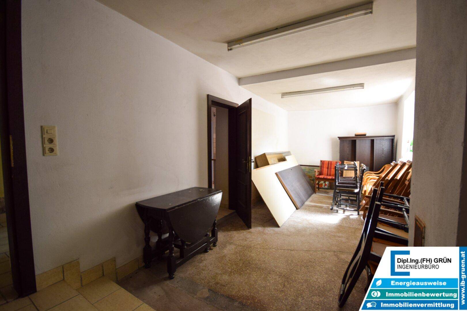 Leerer Raum mit weiß gestrichenen Wänden und einem dunklen Holztisch.