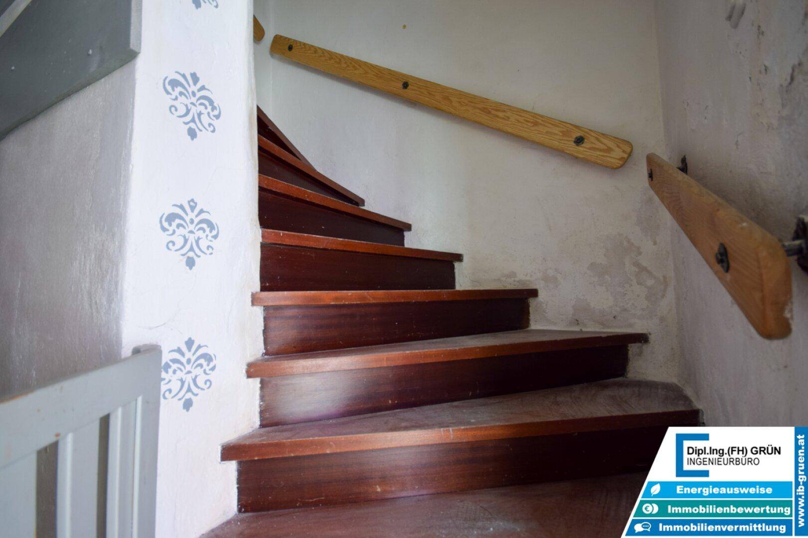 Holztreppe mit geschwungenen Stufen und handgemalten Verzierungen an der Wand.