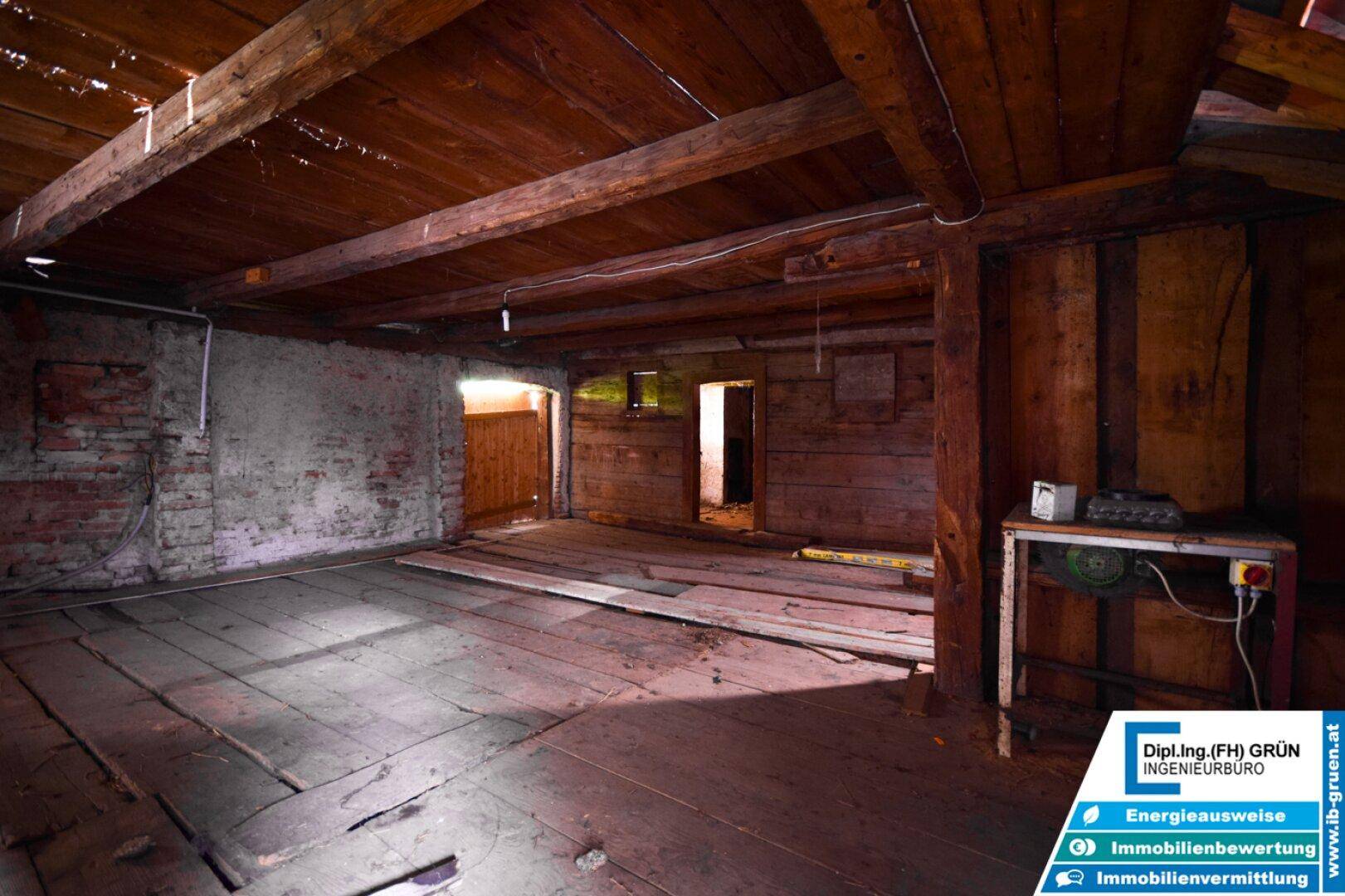 Geräumiger Dachboden mit sichtbaren Holzbalken, Holzdielenboden und rustikalem Charme.