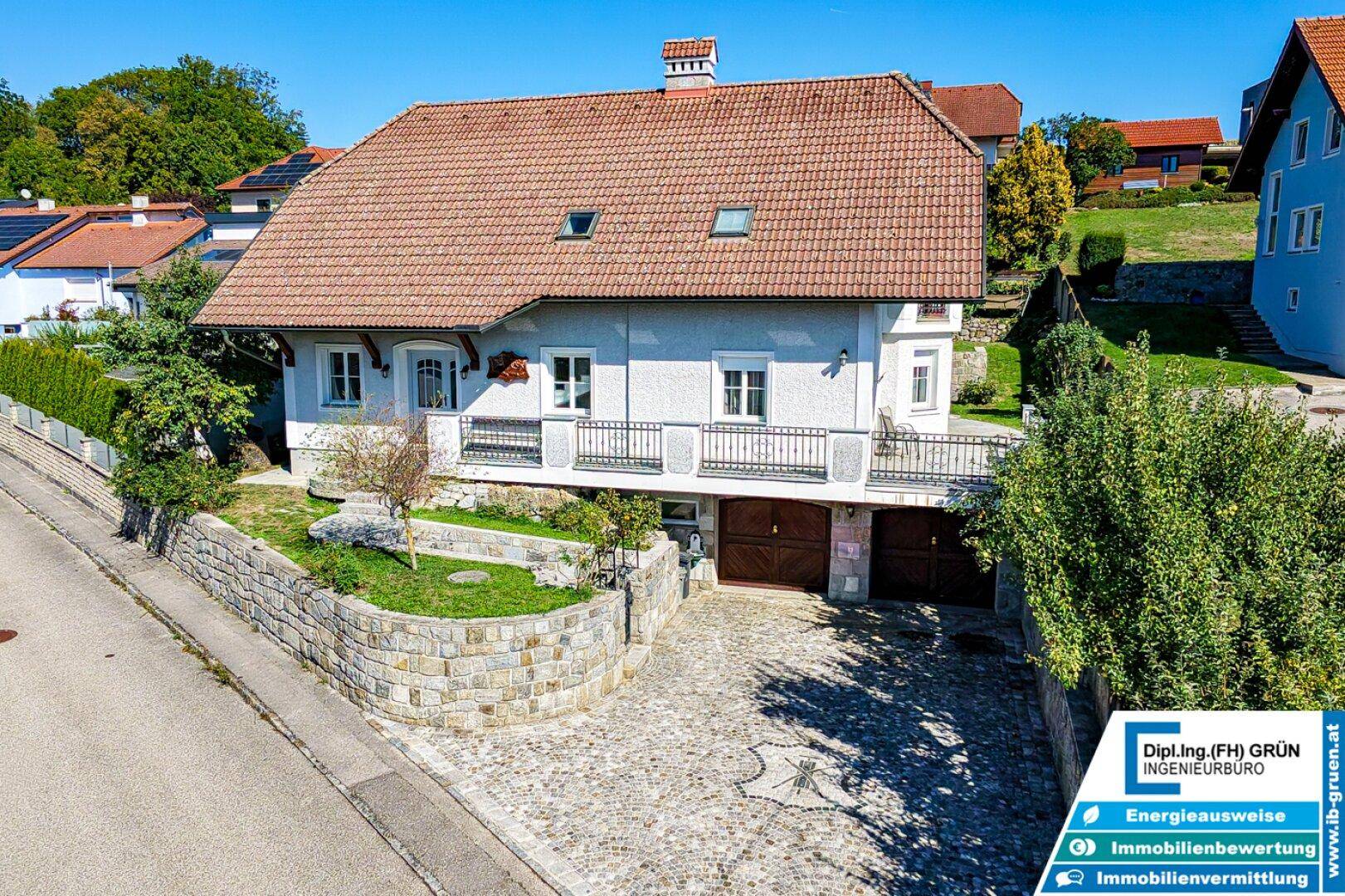 Ansicht des Hauses von der Straße mit gepflasterter Auffahrt und integrierter Garage.