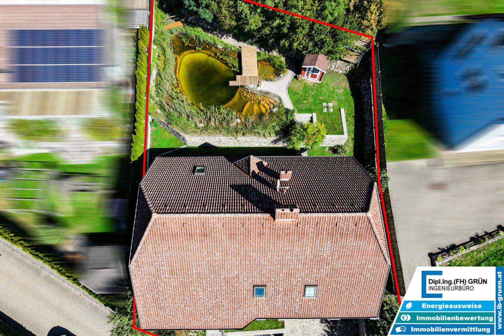 Luftaufnahme des Grundstücks mit eingezeichneten Grenzen und Teich im Gartenbereich.