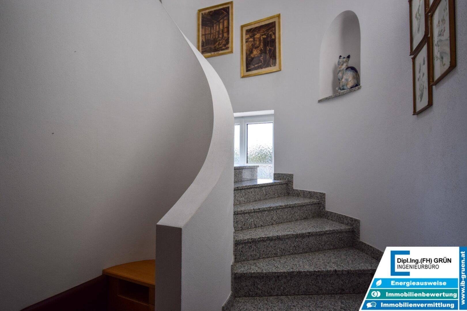 Geschwungene Treppe mit Granitstufen und heller Wandgestaltung.