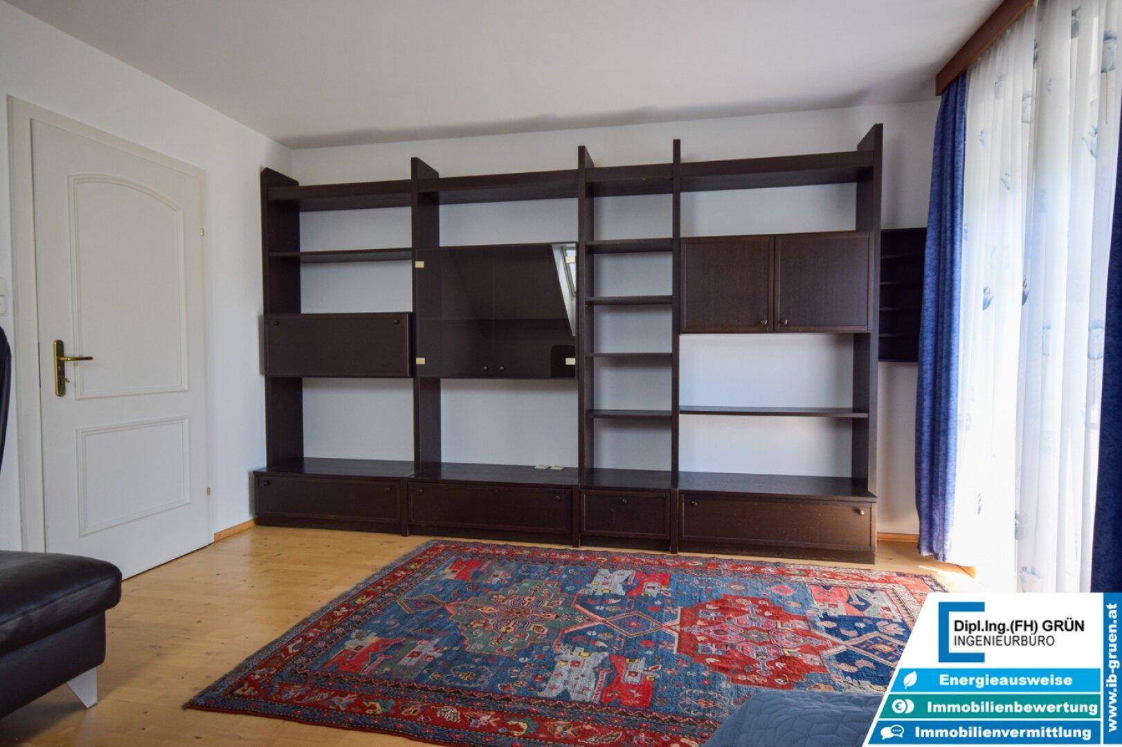 Geräumiges Schlafzimmer mit großem Bücherregal und Holzboden, ideal für Stauraum.