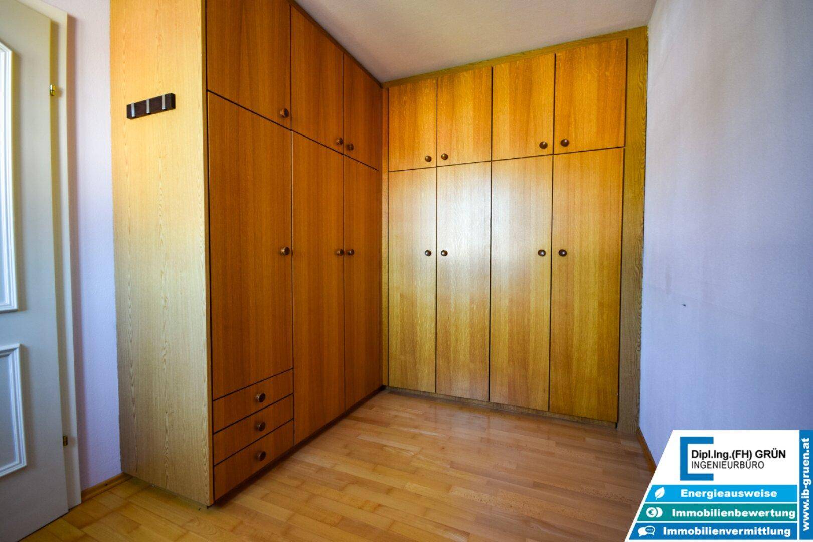 Einbauschränke aus Holz bieten viel Stauraum in diesem Zimmer mit Holzboden.