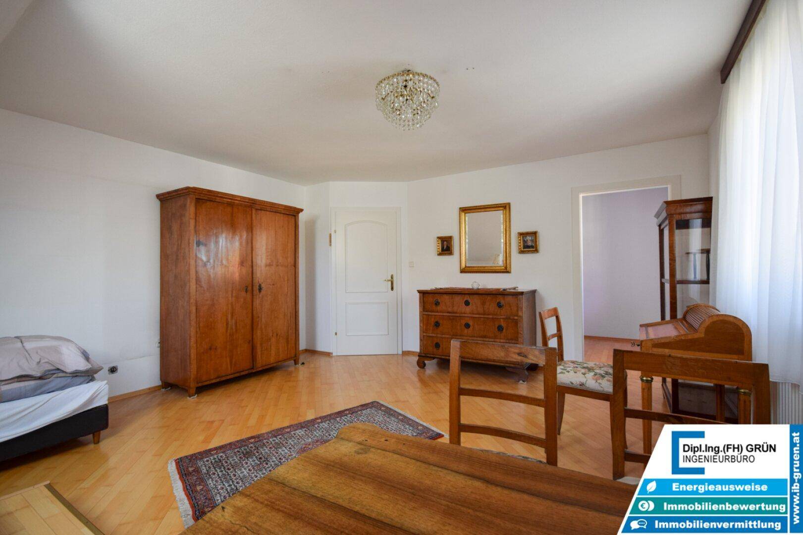 Geräumiges Zimmer mit Holzboden und traditionellen Holzmöbeln, gut erhalten und hell.