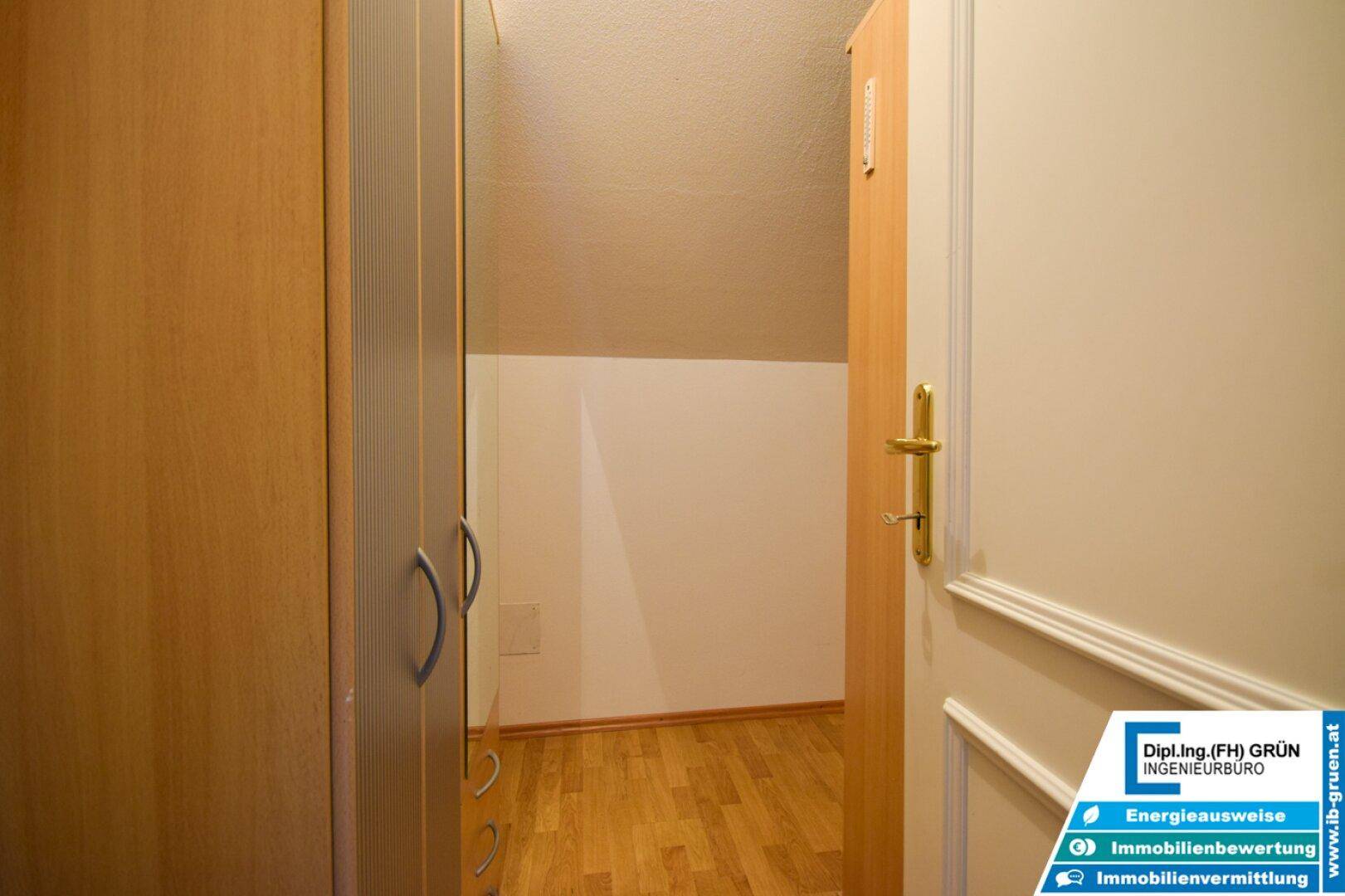 Schmaler Flur mit Einbauschränken und Holzboden, bietet praktischen Stauraum.