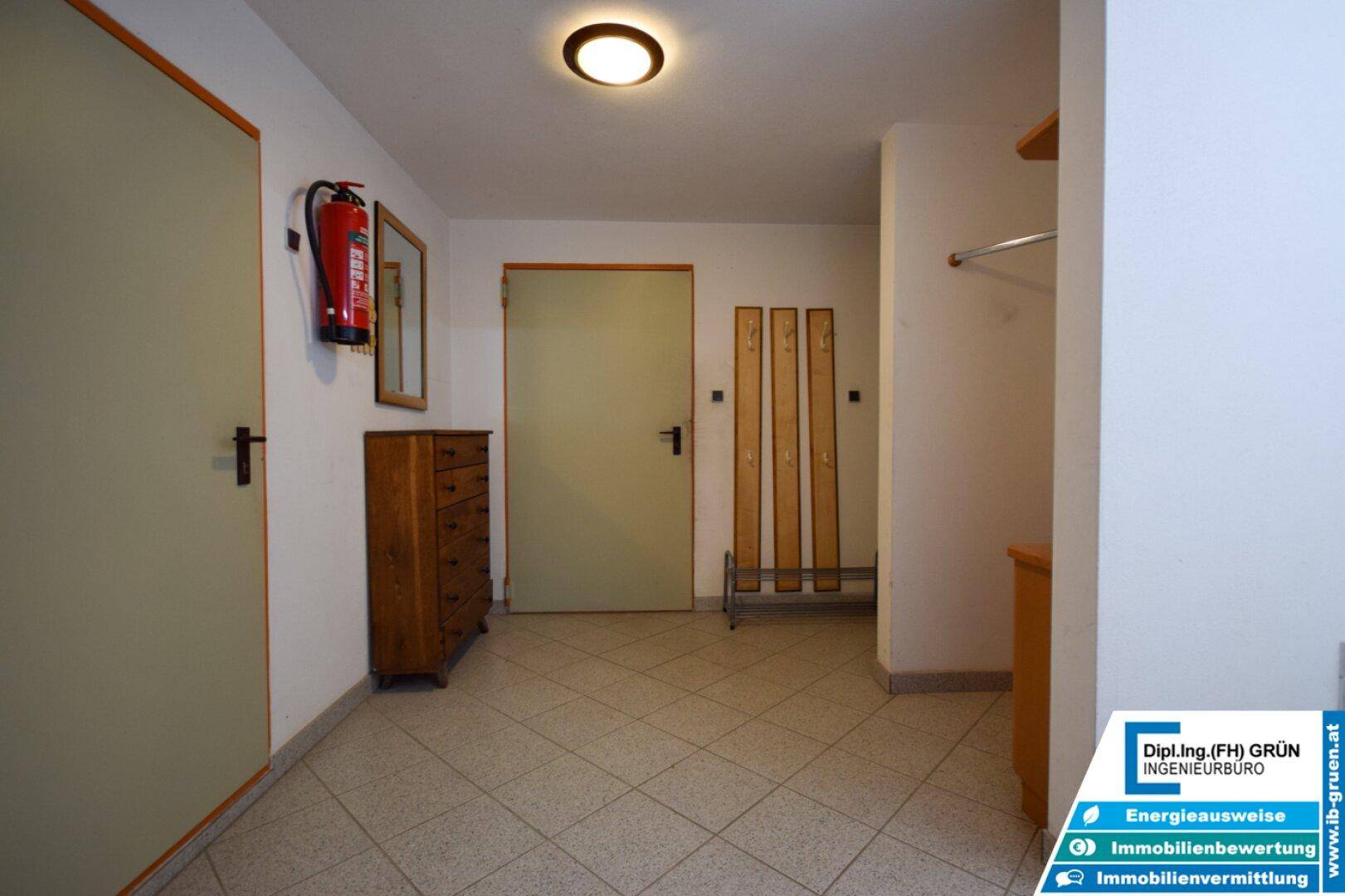 Eingangsbereich mit Fliesenboden, Garderobe und Kommode, funktional und einladend.