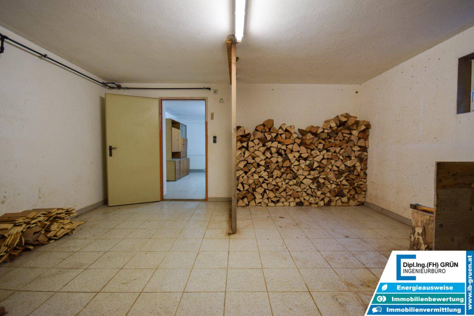 Kellerraum mit gestapelten Holzscheiten und Zugang zu weiteren Räumen, funktional.