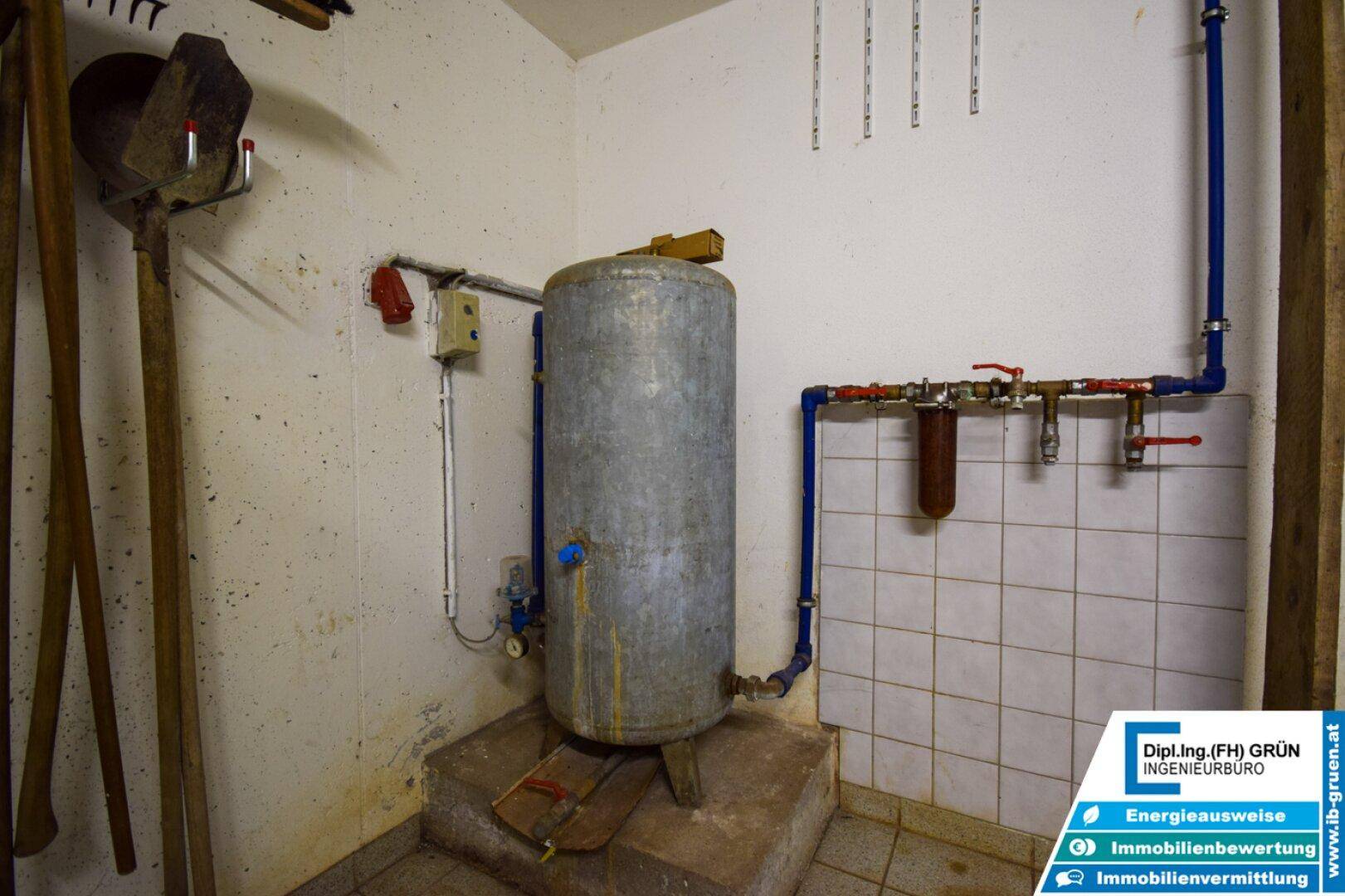Alter Warmwasserspeicher und Rohrleitungen in einem funktionalen Kellerraum.