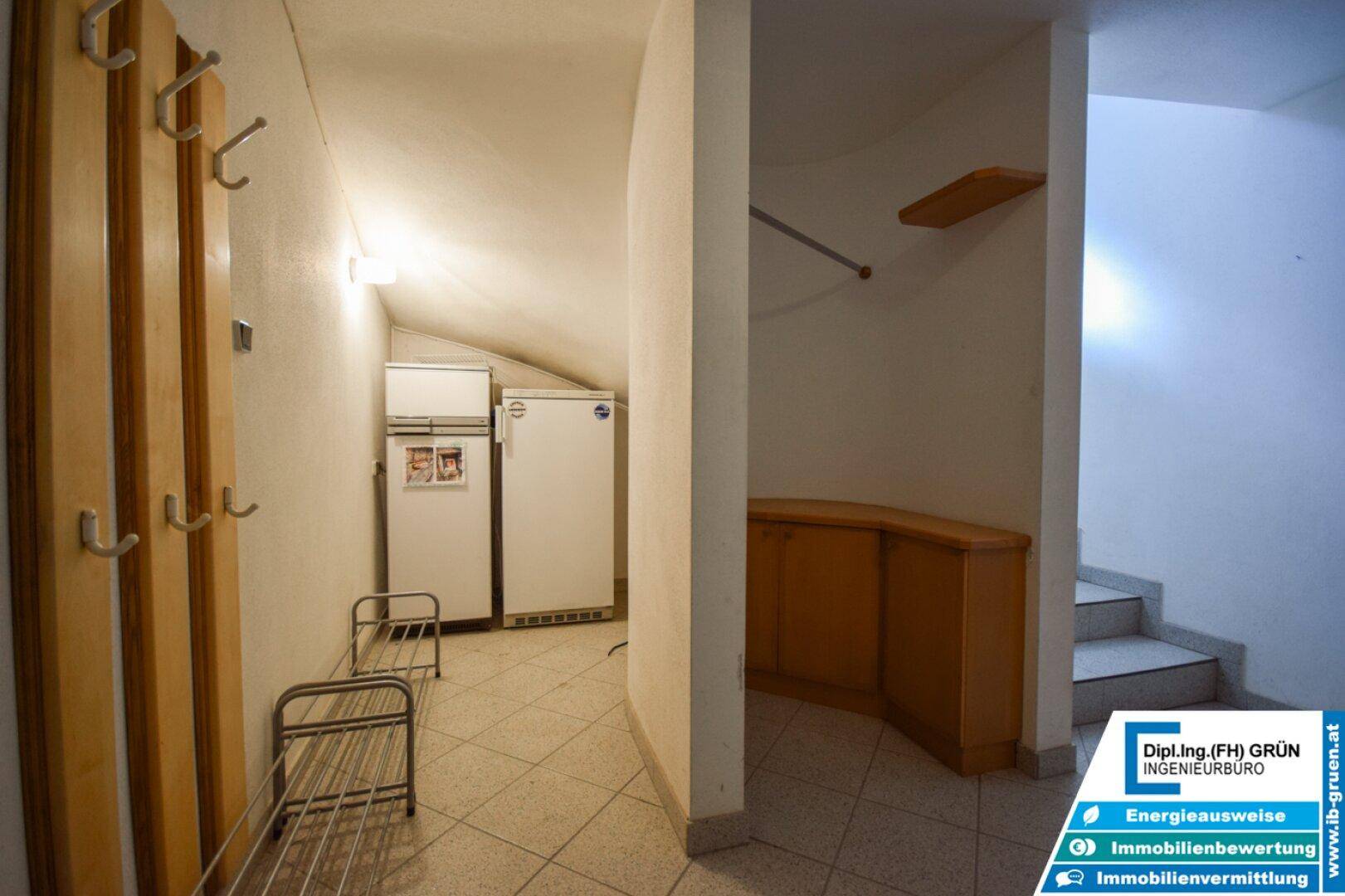 Flur im Dachgeschoss mit schräger Decke, Garderobe und Zugang zu einer Treppe.