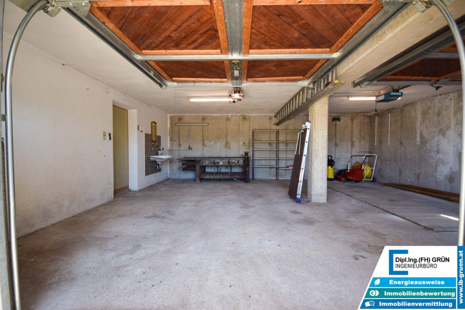 Große Garage mit viel Platz, Betonwänden und einem Fenster für Tageslicht.