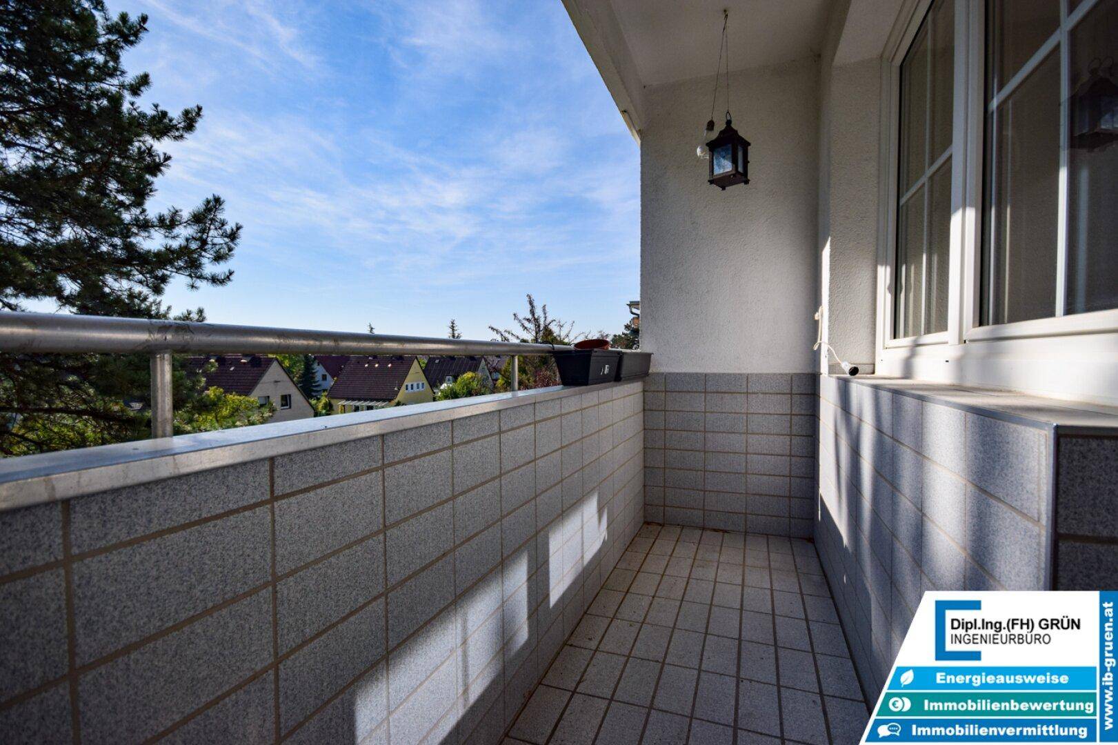 Leerer Balkon mit Fliesenboden und Metallgeländer, bietet eine weite Aussicht.