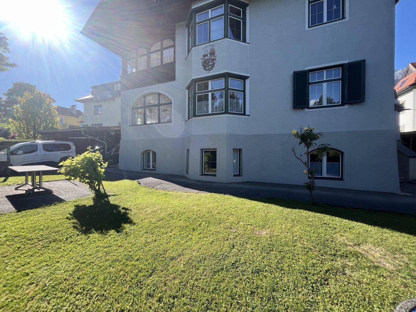Sonnige Ansicht des Gebäudes mit gepflegtem Rasen und traditioneller Architektur.