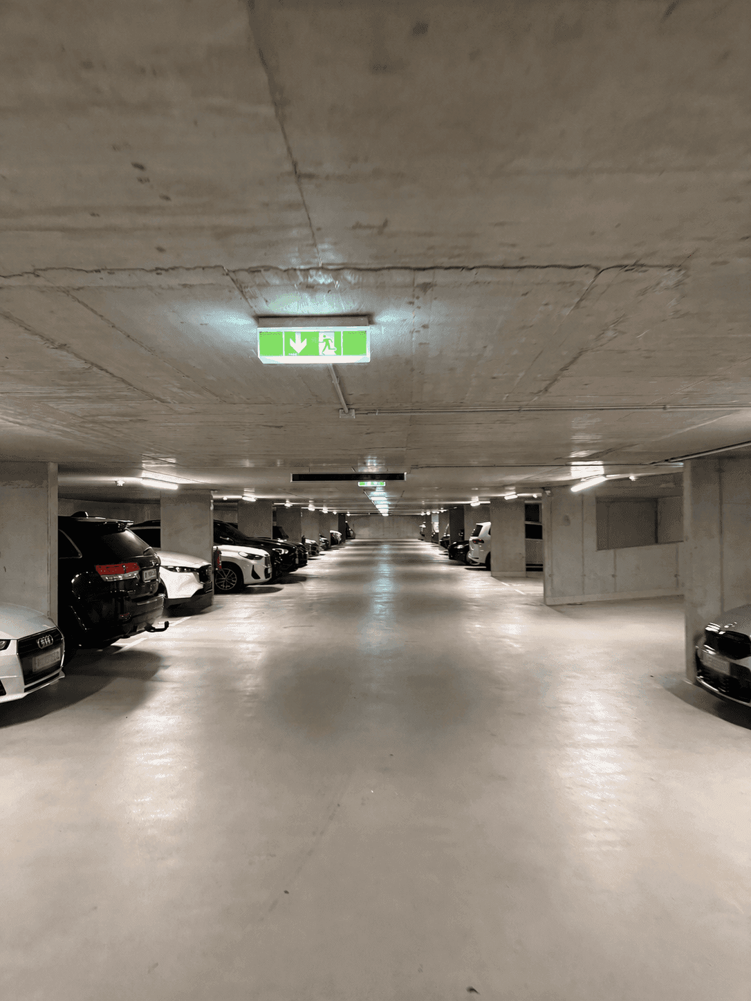 Tiefgarage mit zahlreichen Parkplätzen und Betonwänden.
