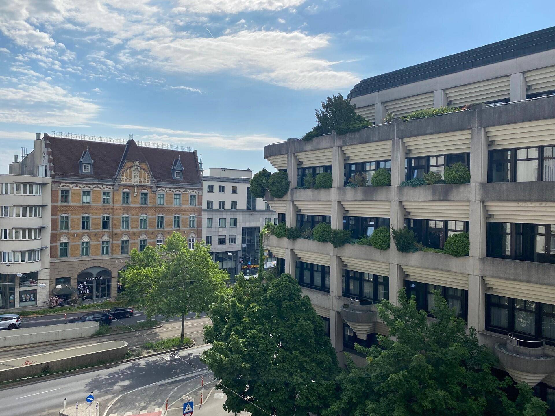 Blick auf die städtische Umgebung mit verschiedenen Gebäuden und einer belebten Straße.