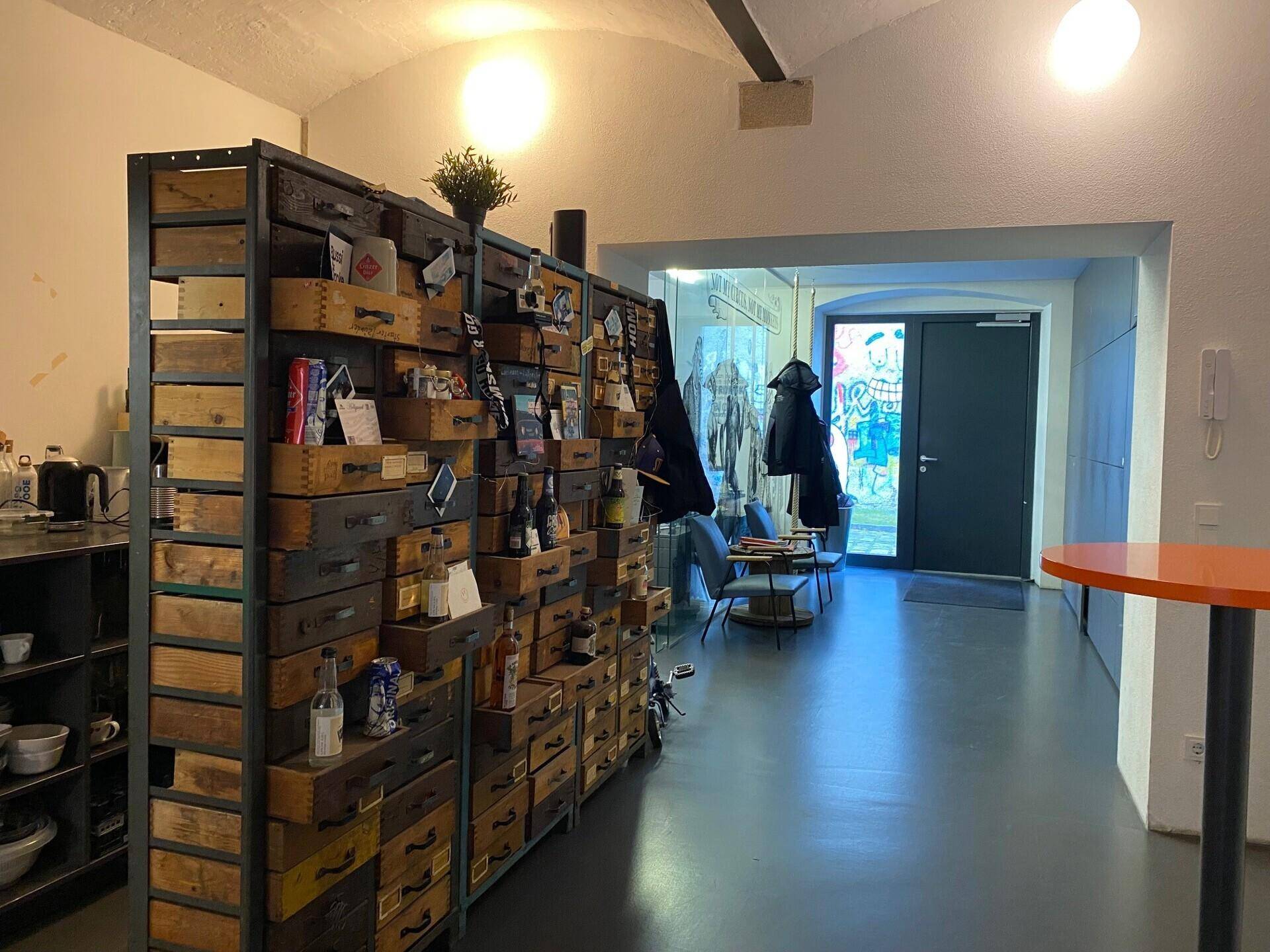 Langer Bürogang mit einem einzigartigen Aufbewahrungsmöbel aus Holzkisten und einer markanten gewölbten Decke.