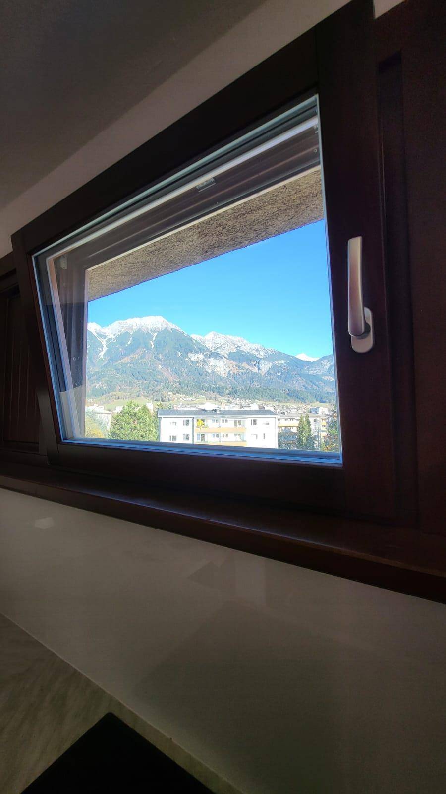 Fensterblick auf die beeindruckende Berglandschaft mit schneebedeckten Gipfeln.