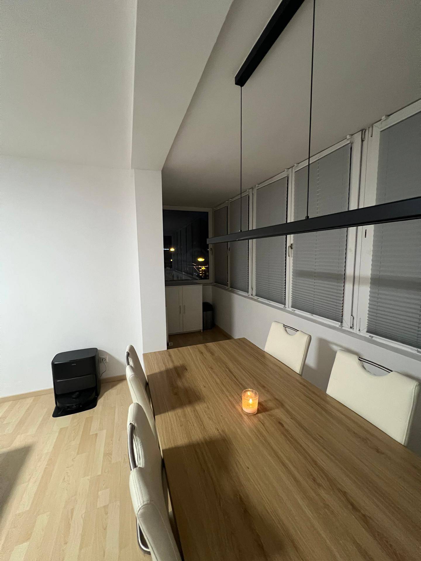 Heller Essbereich mit Holztisch, modernen Stühlen und Blick auf die Fensterfront.
