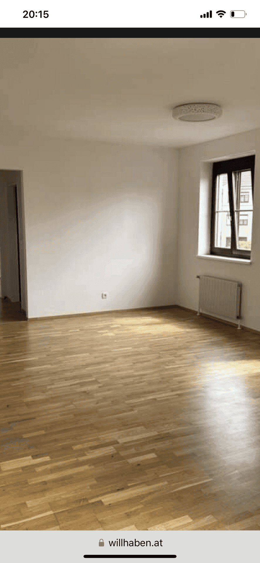 Geräumiger Raum mit hellem Parkettboden und einem Fenster, das viel Tageslicht hereinlässt.