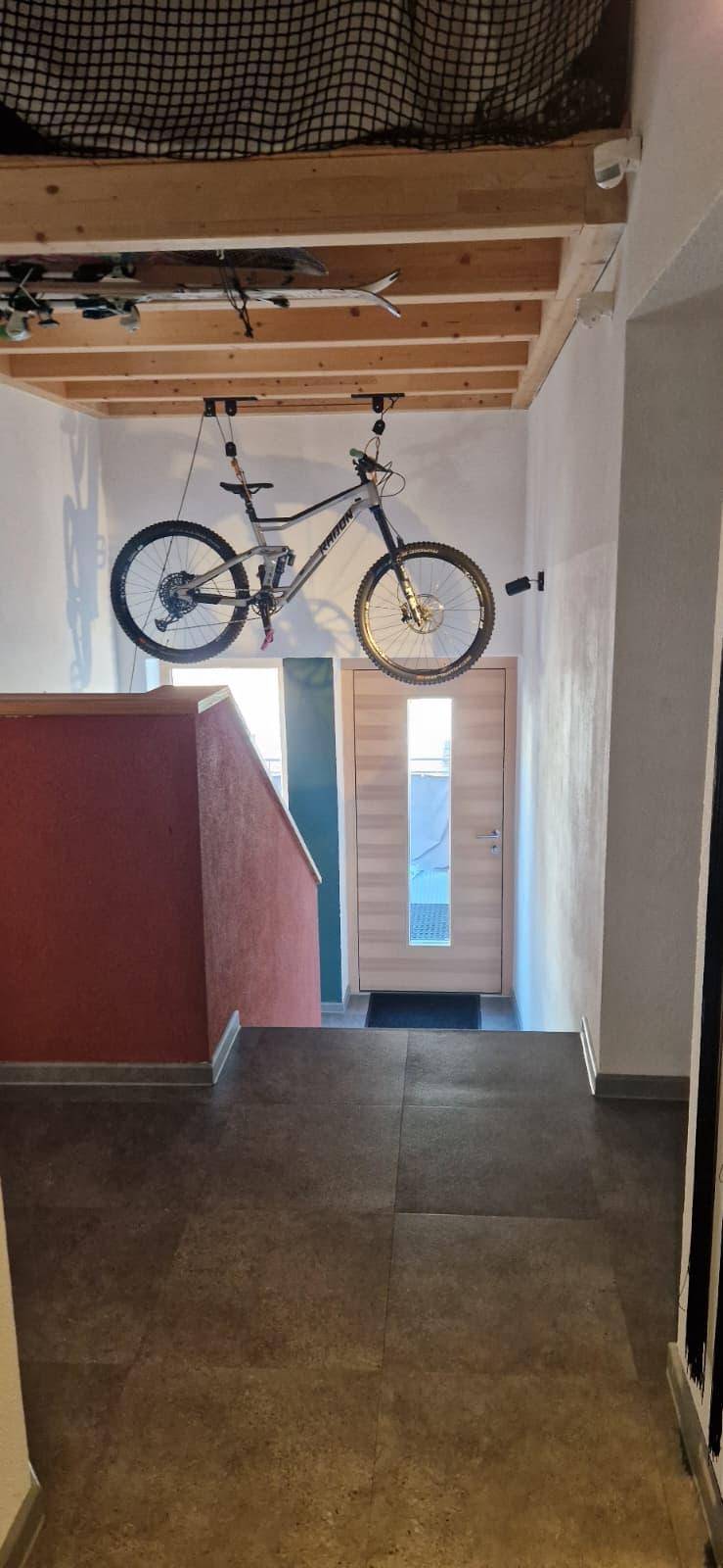 Flurbereich mit Holzbalkendecke und einer hängenden Mountainbike-Aufbewahrung.