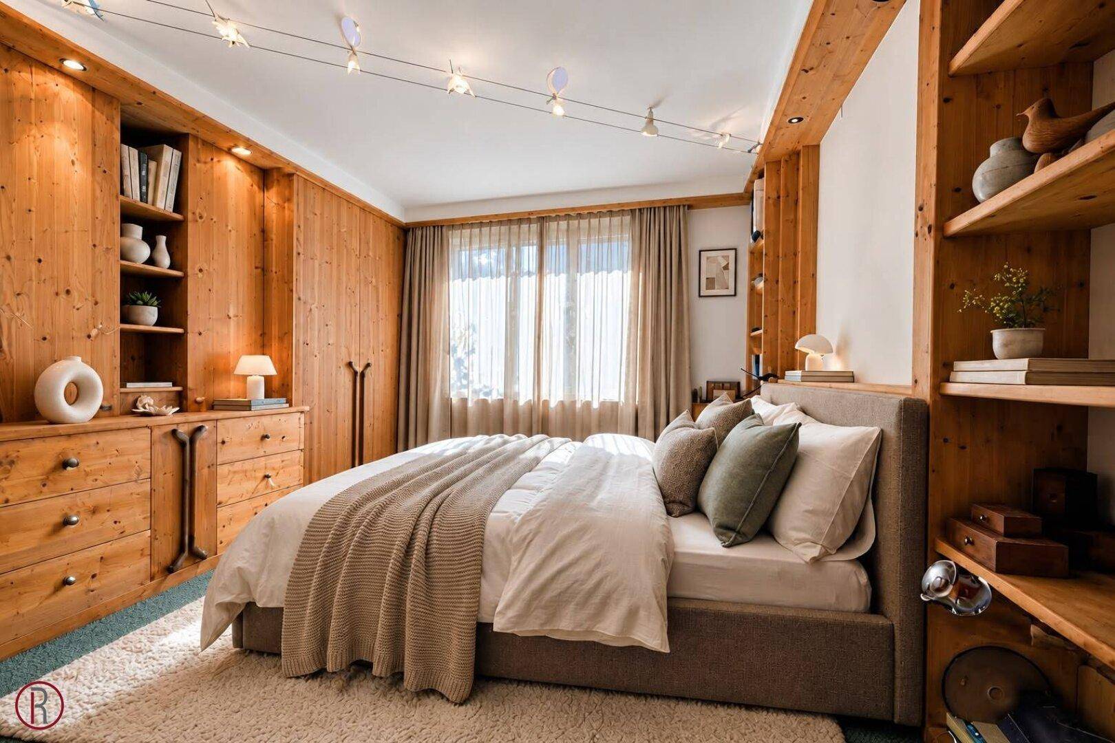 Schlafzimmer im alpinen Stil mit viel Holz, Einbauschränken und gemütlicher Atmosphäre.