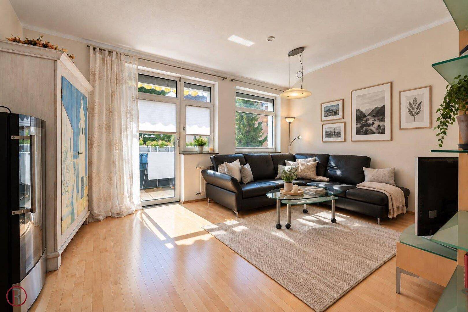Geräumiges Wohnzimmer mit Zugang zum Balkon, Parkettboden und viel Tageslicht.