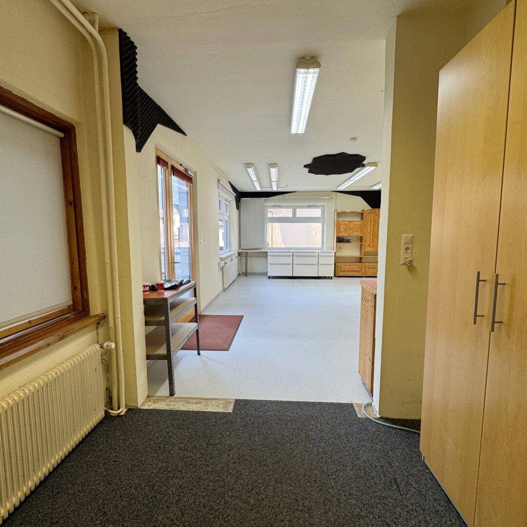Übergangsbereich mit Teppichboden, Einbauschränken und Blick in den angrenzenden Raum.