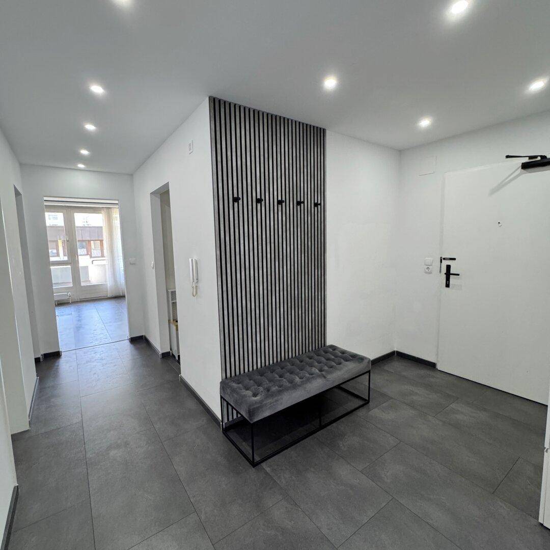 Geräumiger Flur mit moderner Garderobe und Blick auf den hellen Wohnbereich mit Balkonzugang.