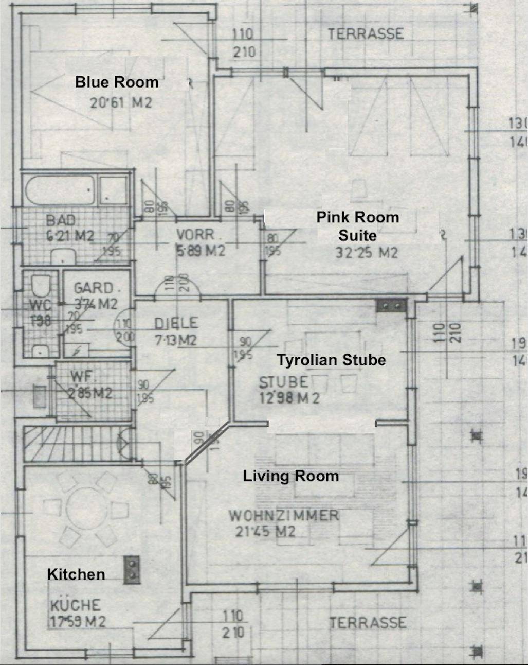 Grundriss des Erdgeschosses mit Wohnzimmer, Küche, Bad und Zugang zu zwei Terrassen.