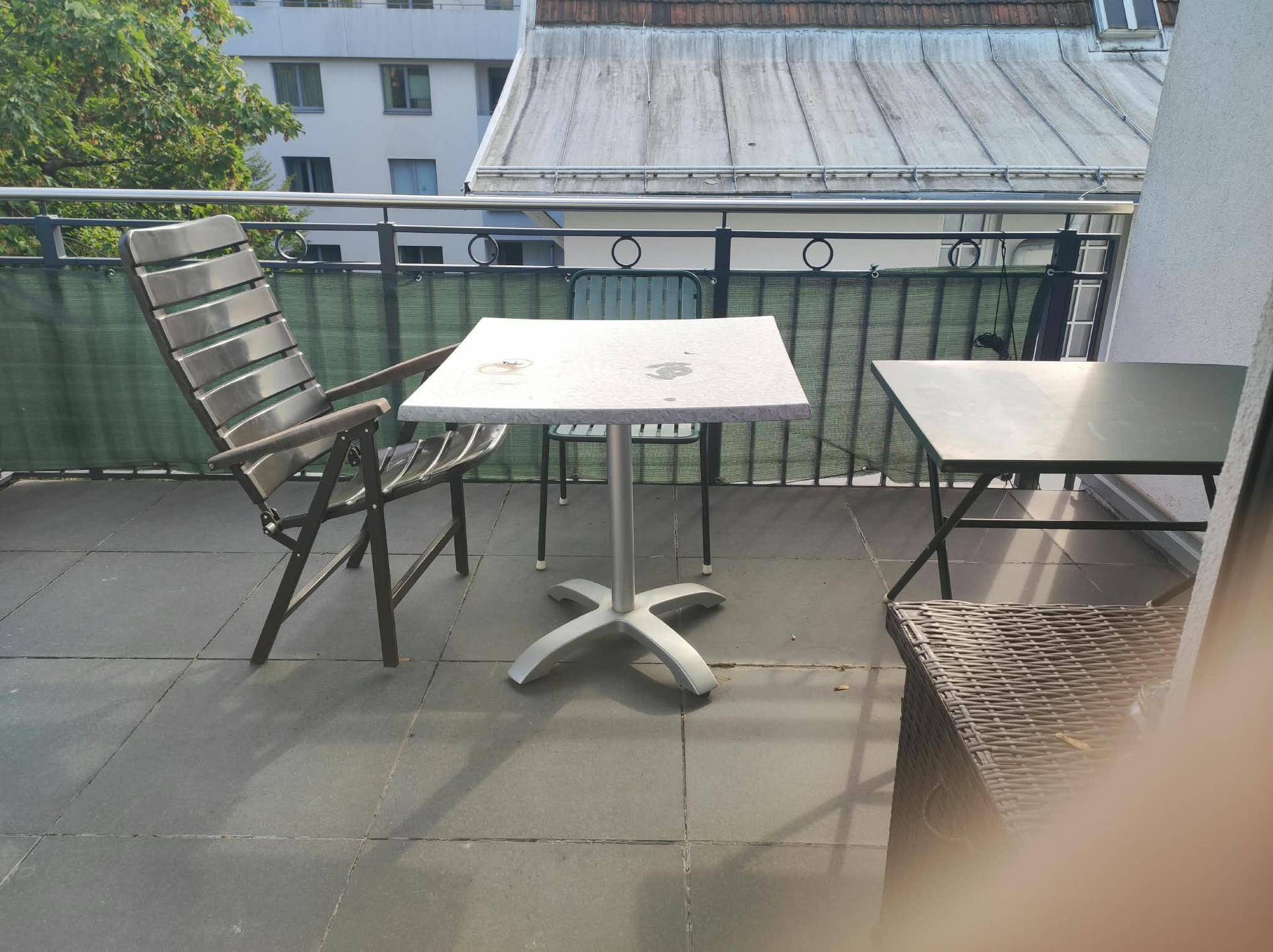 Balkon mit Tisch und Stühlen, ideal für Mahlzeiten im Freien mit Blick auf die Umgebung.